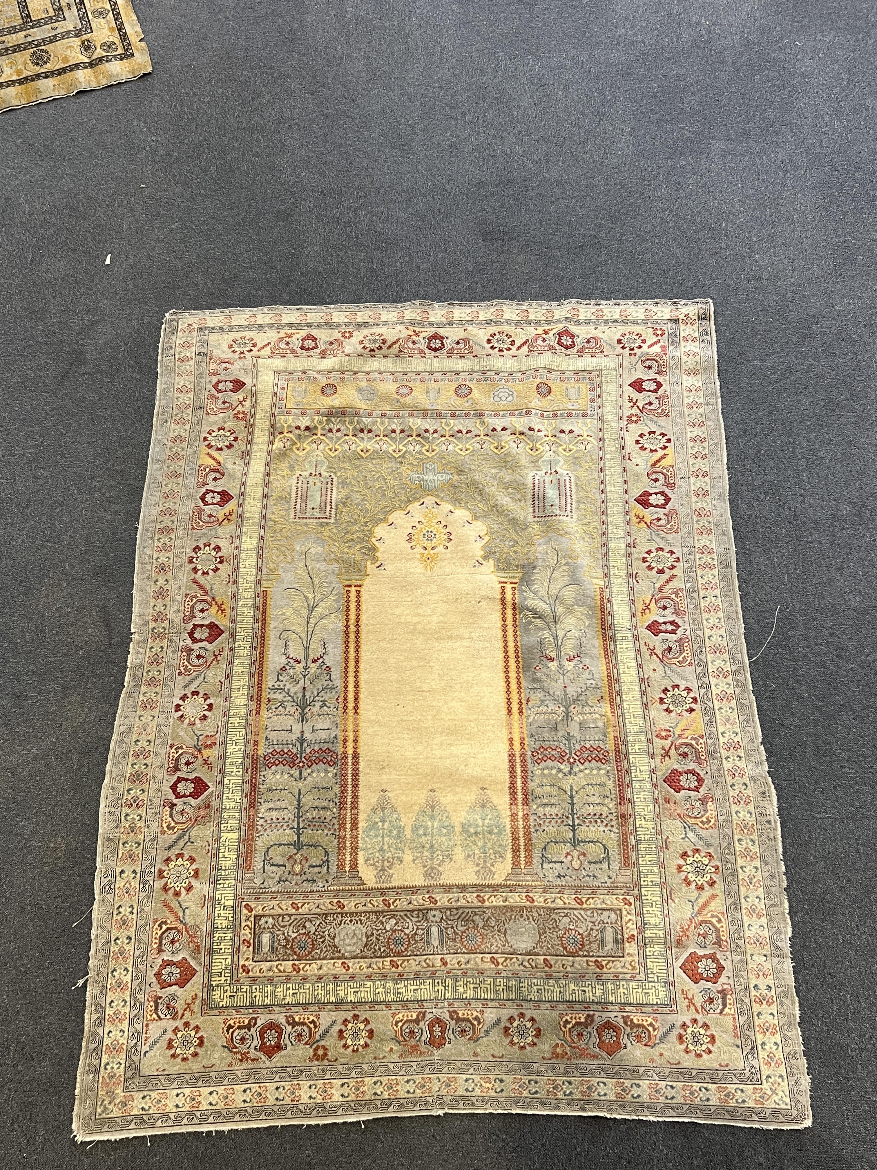 A Turkish silk prayer rug, with central mihrab and stylised floral borders, 205 x 122cm. Condition - worn and faded throughout, all edges worn with a degree of losses.